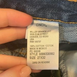 These are a pair of high waisted cinch jeans. They are a dark blue.